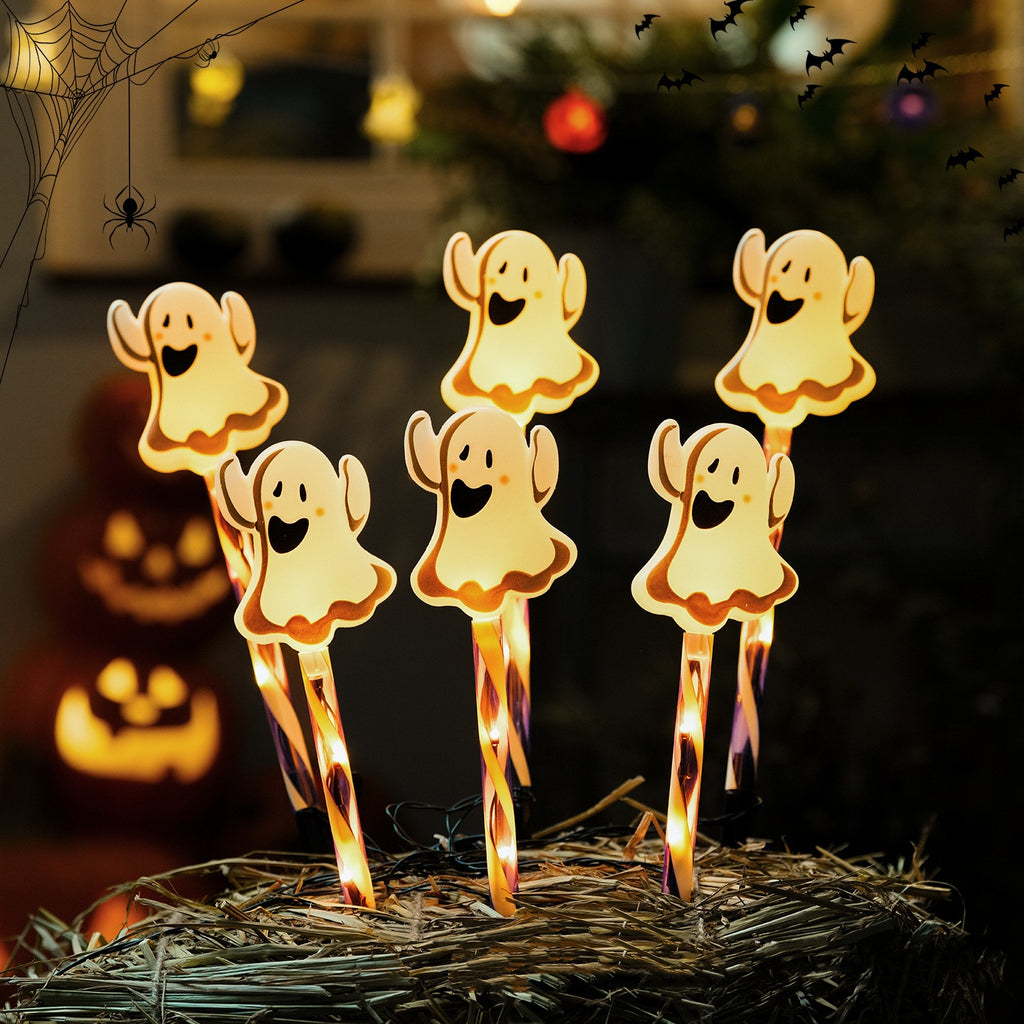 Halloween ghost LED yard stakes glowing outdoors near jack-o-lanterns