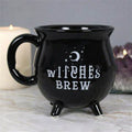Black Witches Brew cauldron mug with moon and stars design styled with candle and crystal